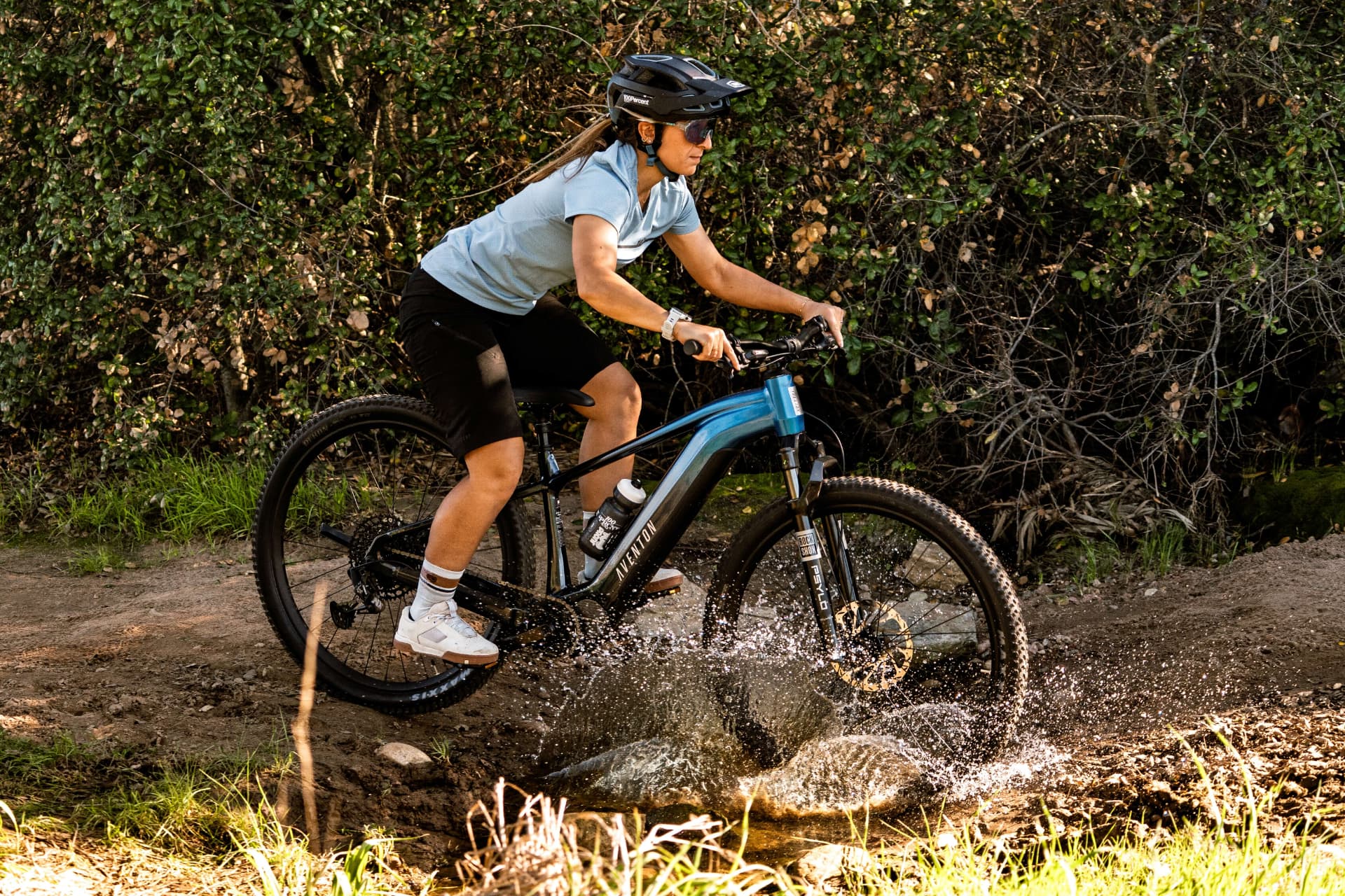Ciclista cruzando un arroyo con una Aventon Ramblas en el trail