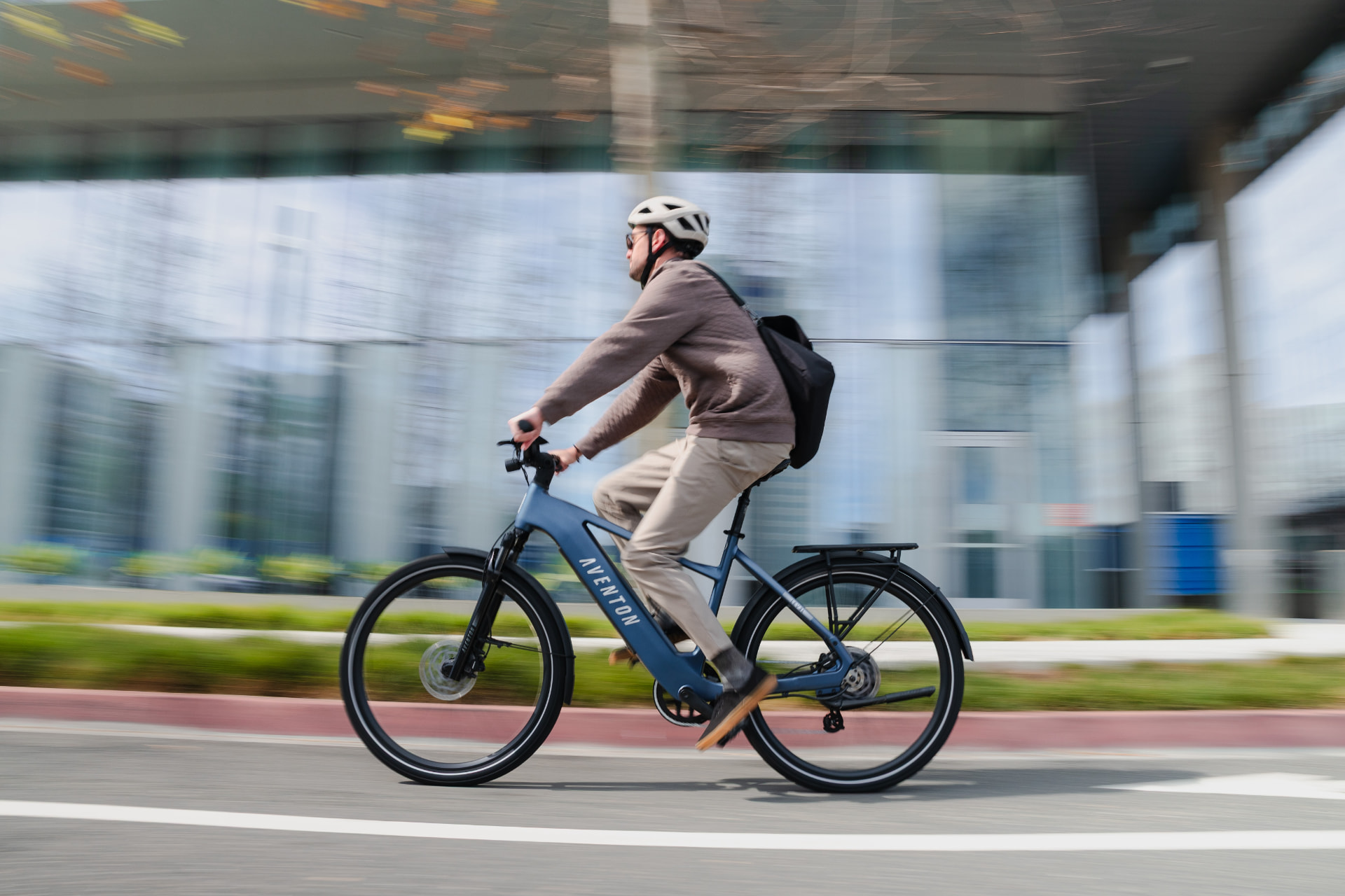 Ciclista Aventon en movimiento sobre una ruta urbana, captura con efecto de panneo