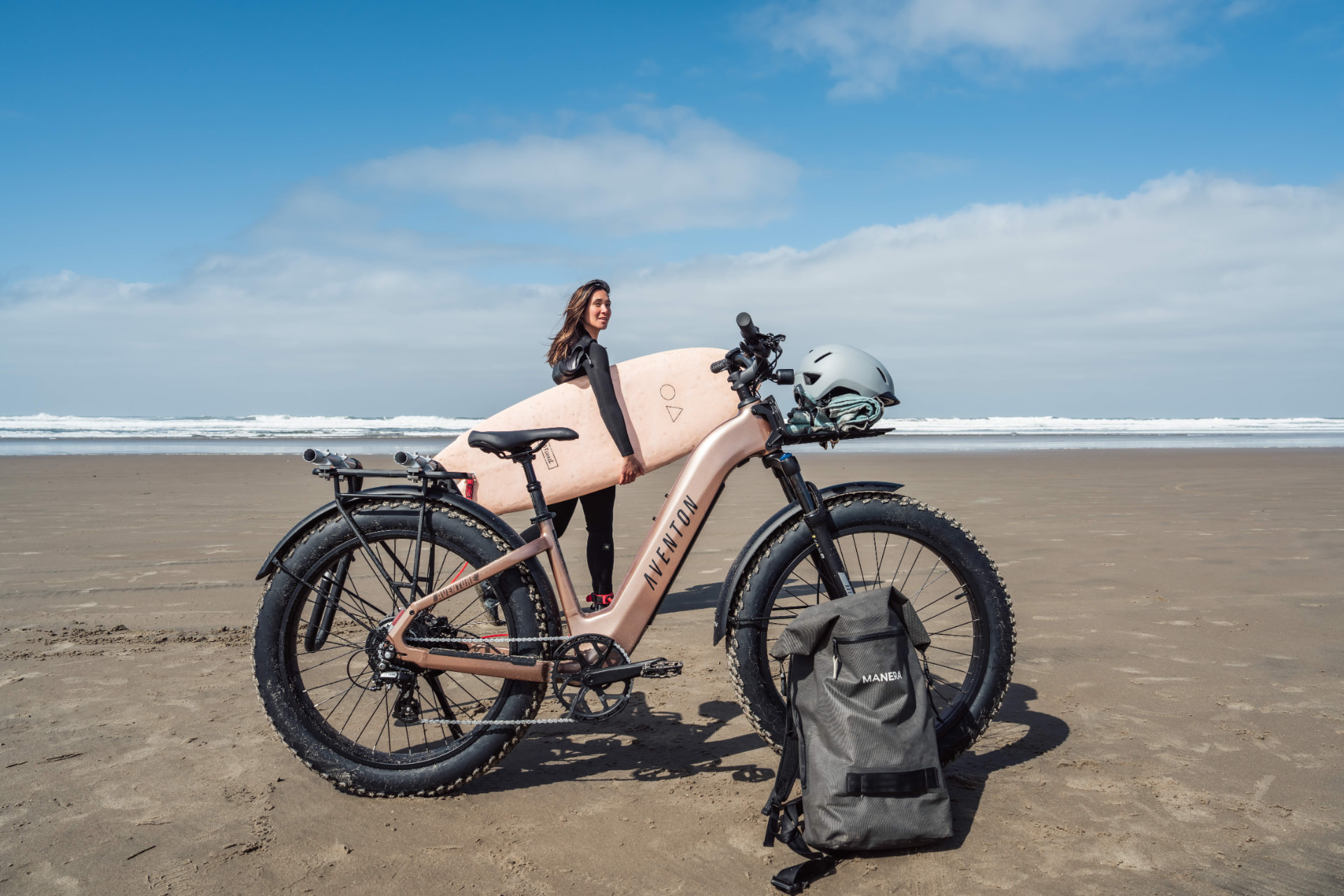 Ciclista junto a una Aventon Aventure con cubiertas anchas en la playa